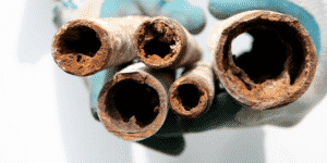 old corroded pipes being held by plumber